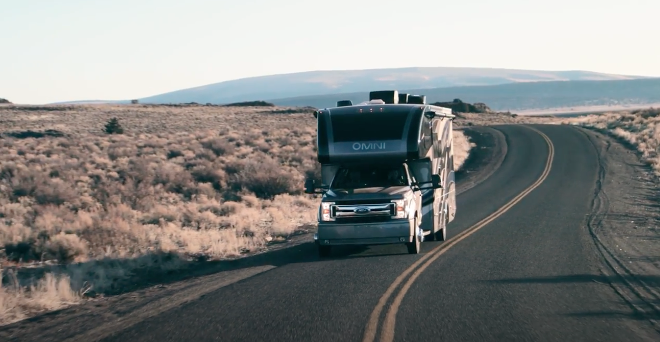 RV driving on scenic open highway through desert landscape